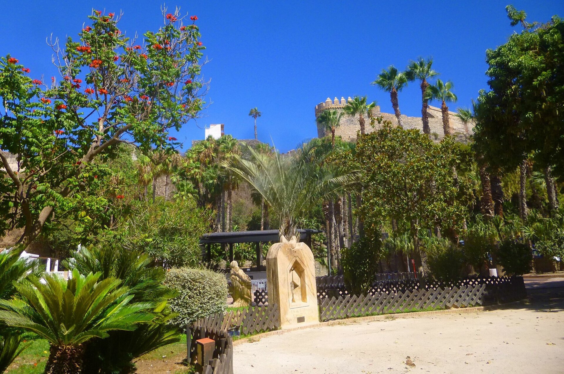 Parque El Majuelo mit den Palmen und der Burg im Hintergrund