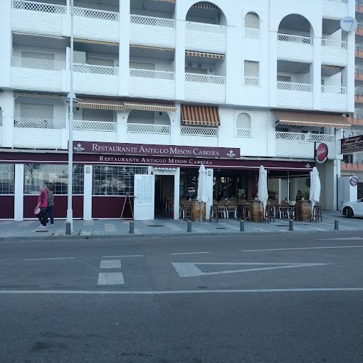 Restaurante Antiguo Mesón Cabrera med vintønder og borde på fortovet